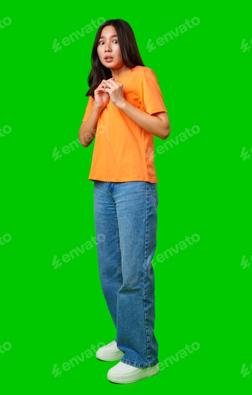 Preview: Young woman in an orange shirt looks surprised against a bright green background