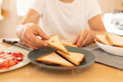 Preview: a woman toasting bread in a toaster oven in her kitchen