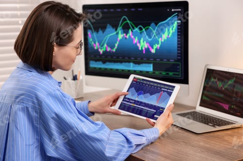 Preview: Stock exchange. Woman analysing financial market on tablet at wooden table indoors