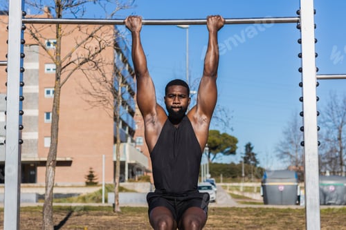 Preview: Strong black sportsman working out on bar in town