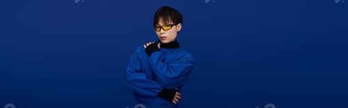 Preview: Confident young man in vibrant blue outfit stands against a bold blue background showcasing style