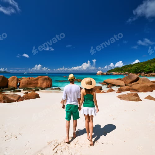 Preview: Couple In Green Walking On A Tropical Beach At Seychelles