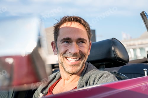 Preview: Portrait of smiling mature man sitting in his sports car