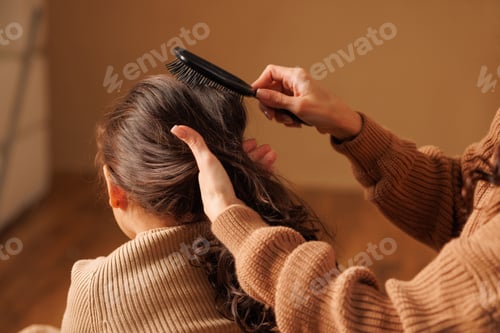 Preview: Woman Combs Child's Hair Indoors at Home