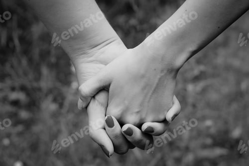 Preview: Gray scale shallow focus shot of a couple holding hands
