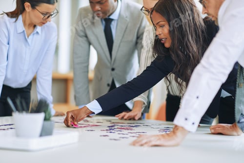 Preview: Diverse businesspeople standing in a boardroom solving a jigsaw puzzle