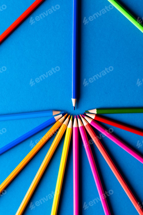 Preview: Close up of multi coloured pencils in circle and copy space on blue background