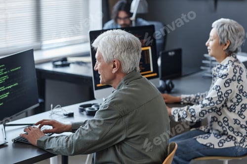 Preview: White haired man using computer in coding class for elderly