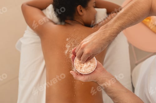 Preview: African American woman receiving a back scrub treatment
