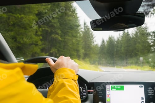 Preview: Tourist drives car through pass in Alps on rainy day