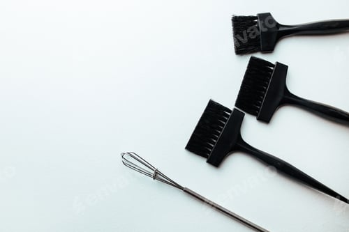 Preview: a broom and a brush for dyeing hair on a white background. hair coloring concept and parekmahep inst