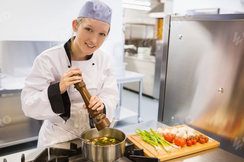 Preview: Cheerful Woman Spicing Soup With Pepper