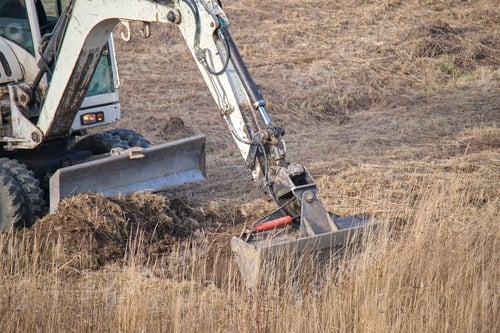 Preview: Earth moving tractor preparing place for future house foundation