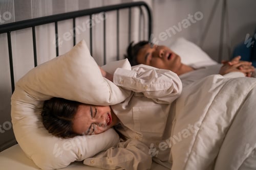 Preview: Asian woman feel frustrated from husband snoring while sleep at night.