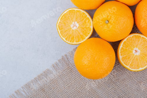 Preview: Fresh oranges lying on sackcloth on white background