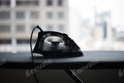 Iron on Ironing Board near Window in Apartment