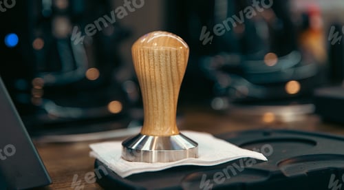 Preview: Close-up of a coffee tamper on a blurred background.