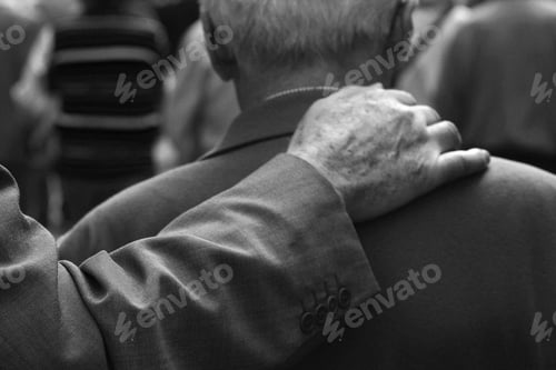 Preview: Grayscale shot of a wrinkled hand on senior man's soldier - the concept of frienship