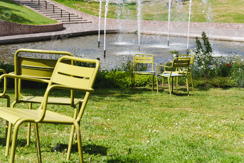 Preview: Movable chairs in the public space of a modern city. Free green steel chairs in the park