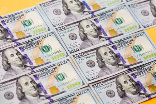 Preview: American Hundred Dollar Bills on a Yellow Background