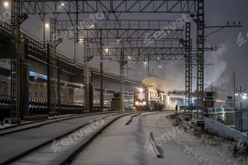 Preview: Retro old Christmas steam train at night in the city on Christmas Eve and New Year in Russia.