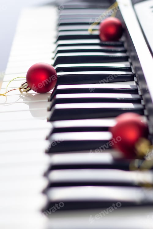 Preview: Close up of piano keyboard with christmas ball. New year background with soft focus