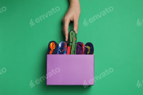 Preview: Bright socks with a print, in a box with a hand.