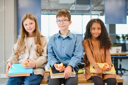 Preview: Multiracial schoolchildren having lunch at the desk during a break in school