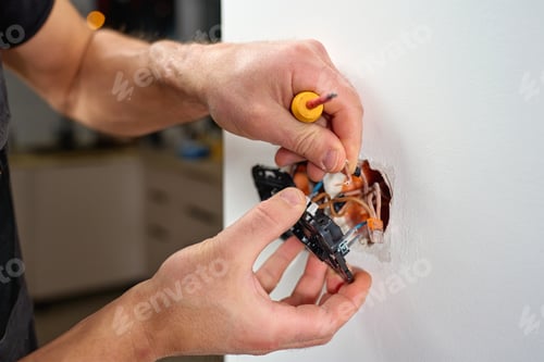 Preview: Electrician installing electrical light switch in wall