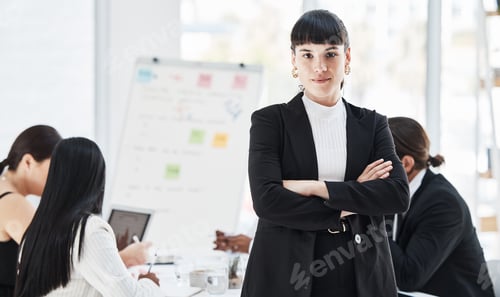 Preview: Portrait of a young businesswoman standing in an office with her colleagues in the background