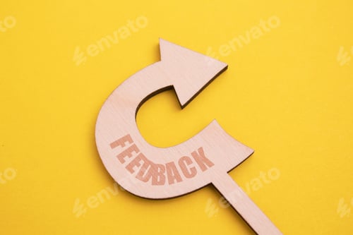Preview: a wooden arrow pointing to the word feedback on a yellow background