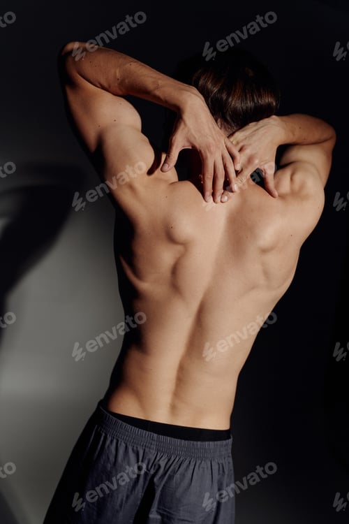 Preview: back view of muscular shirtless man posing on black and grey background