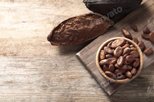 Preview: Flat lay composition with cocoa beans and powder on wooden table, space for text
