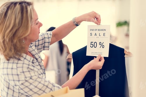 Preview: Woman checking out discounted clothes