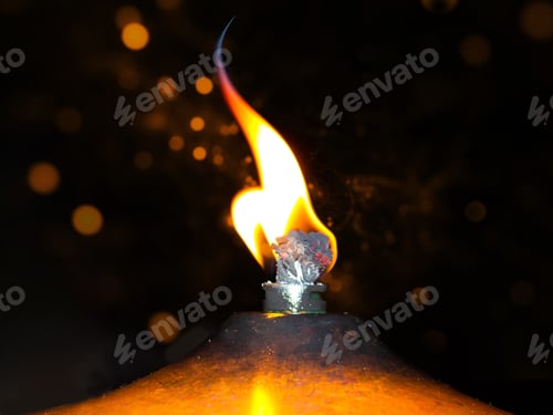 Preview: Wick with fire emitting light in the dark. The concept of removing darkness with a flame.