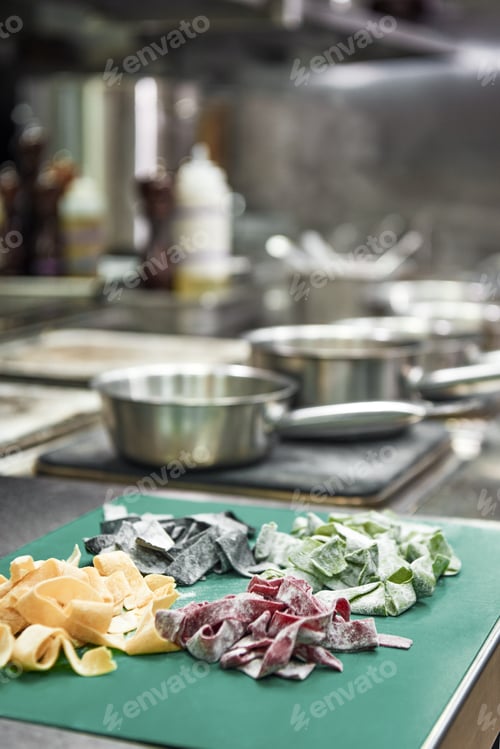 Preview: Great work Close up of colorful homemade pasta lying on the cutting board in kitchen and ready to be