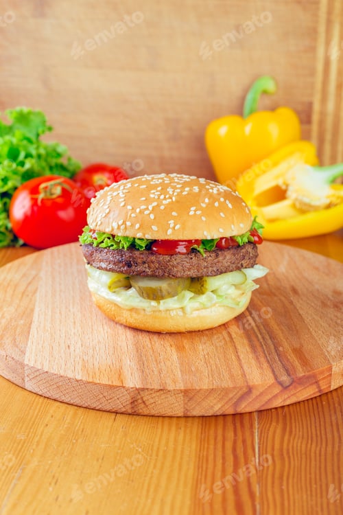 Preview: Deliciously stacked burger with fresh vegetables on a wooden cutting board in a cozy kitchen setting