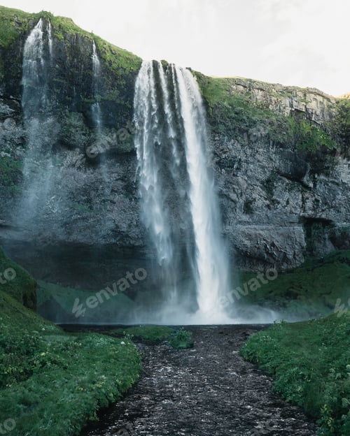 Preview: Breathtaking view of a powerful waterfall surrounded by rocky cliffs in Iceland