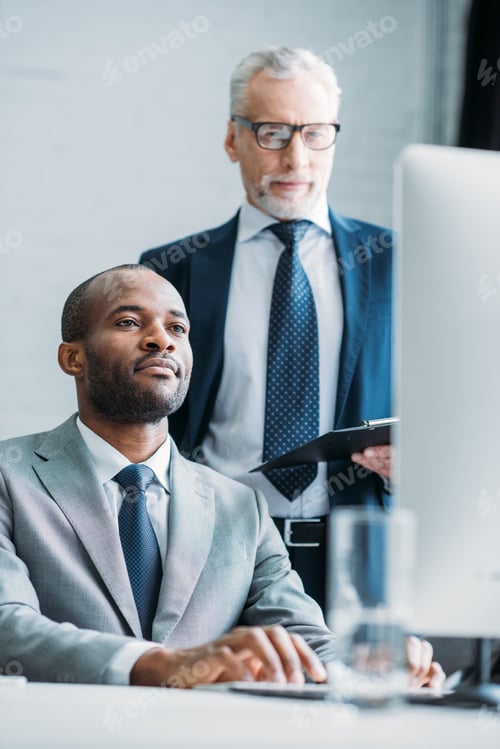 Preview: multiethnic business colleagues looking at computer screen at workplace in office