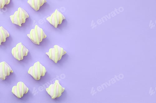 Preview: Colorful marshmallow laid out on violet paper background. pastel creative te