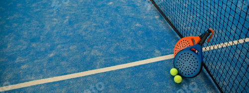 Preview: Padel equipment is on the court with tennis balls close by