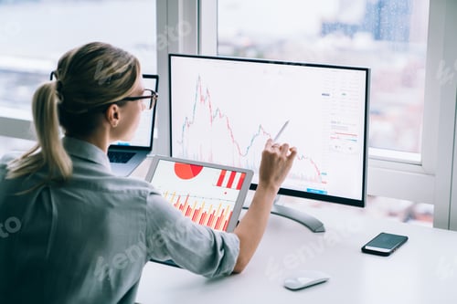 Preview: Unrecognizable trader analyzing graph on computer screen in office