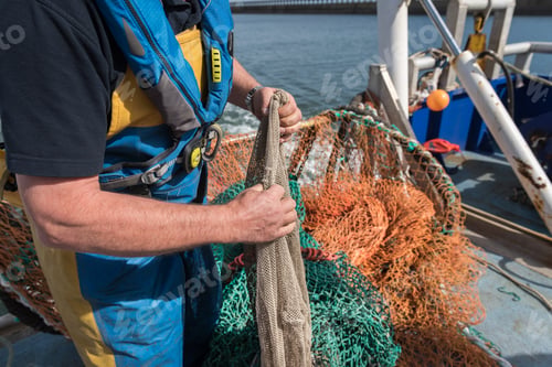 Preview: Fisherman preparing fishing net on research ship, close up