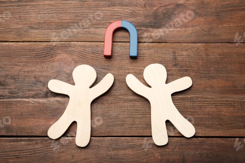 Preview: Magnet attracting people traffic on wooden background, top view. Marketing concept