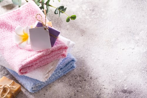 Preview: Spa set from fresh natural bath towels with handmade soap and flower on a light grey background