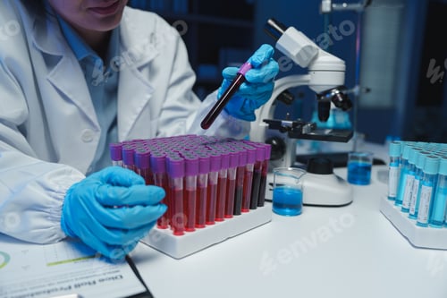 Preview: Medical researcher wearing gloves carefully placing blood sample tube into rack in laboratory settin