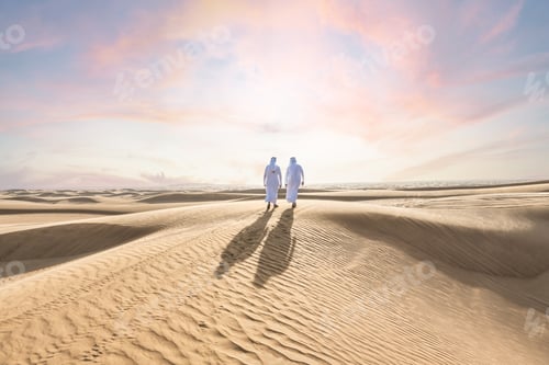 Preview: Two middle-eastern emirati men wearing arab kandura bonding in the desert