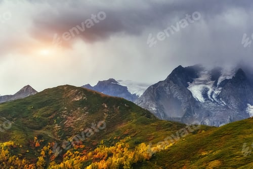 Preview: Sunset over snow-capped mountain peaks.