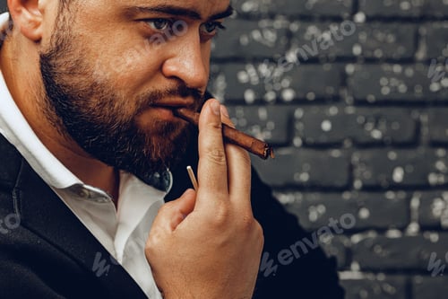Preview: Bearded man smoking cigar against black brick wall