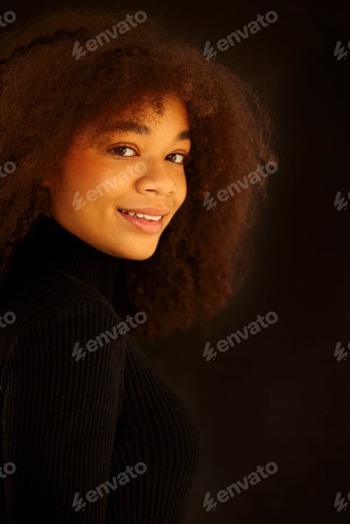 Preview: African beauty. Smiling young african-american woman in black clothes isolated on dark background